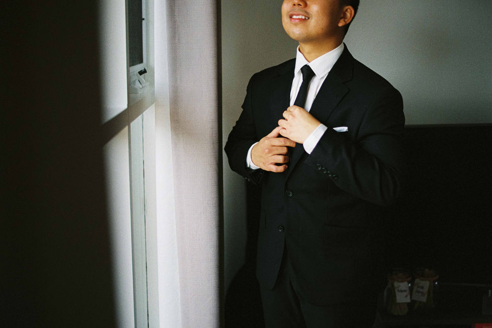 a man in a suit and tie adjusts his tie