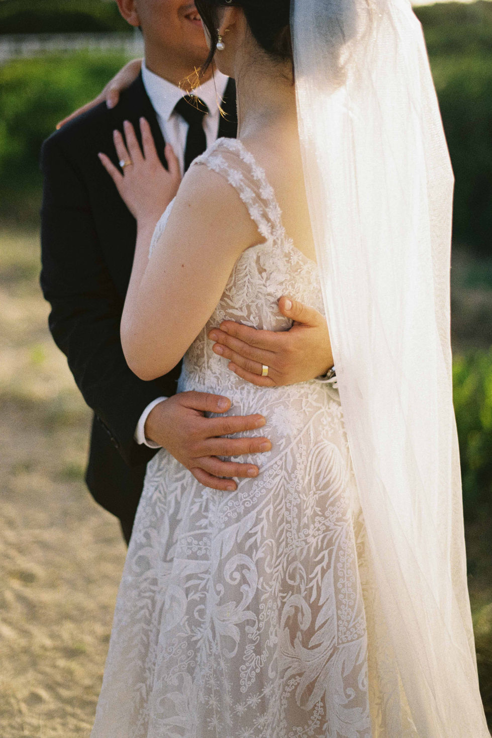 a bride and groom are posing for a picture and the bride is wearing a gold wedding ring