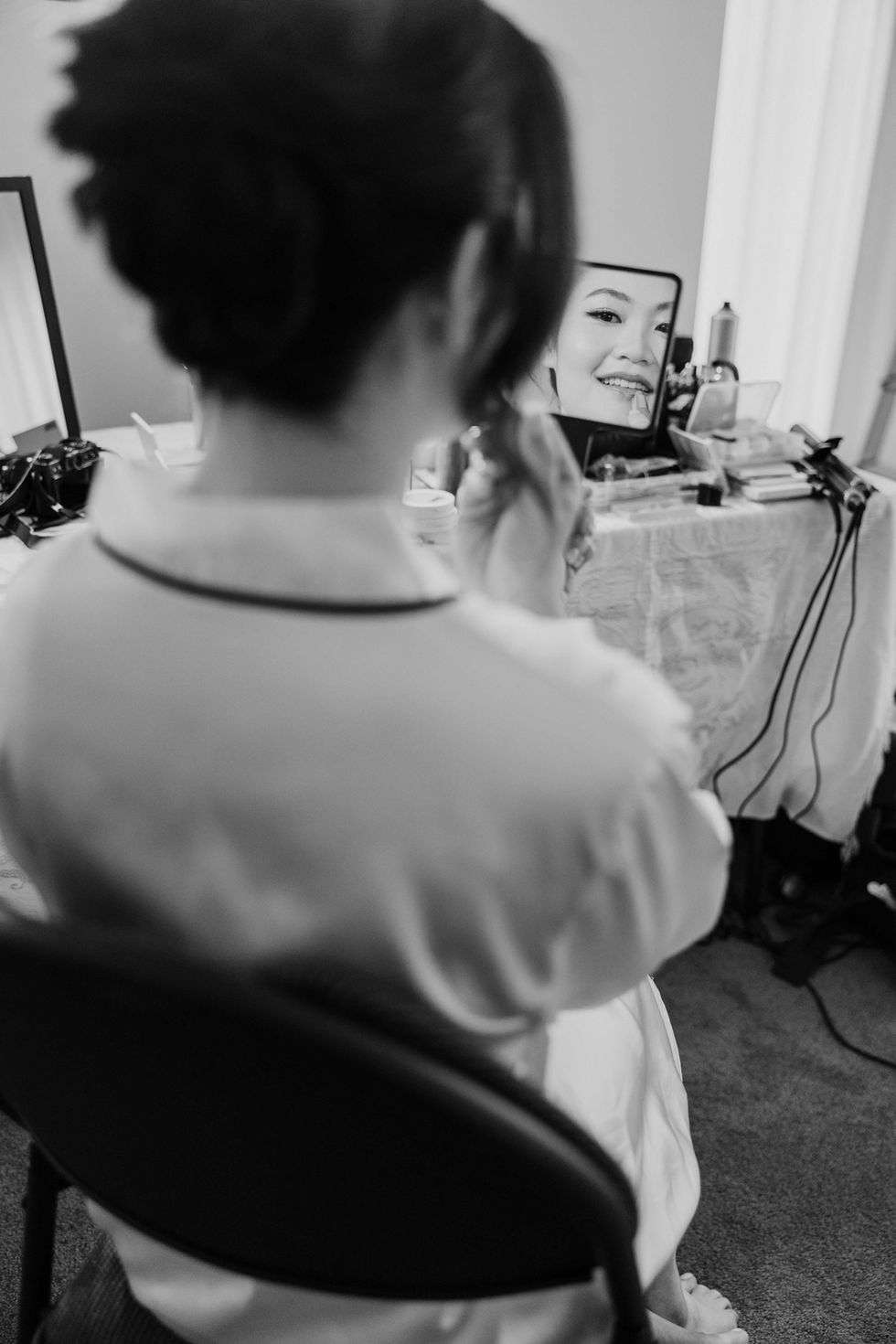 a bride looking at her face in a mirror