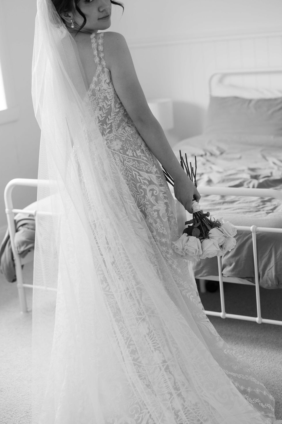 a woman in a wedding dress is holding a bouquet of flowers