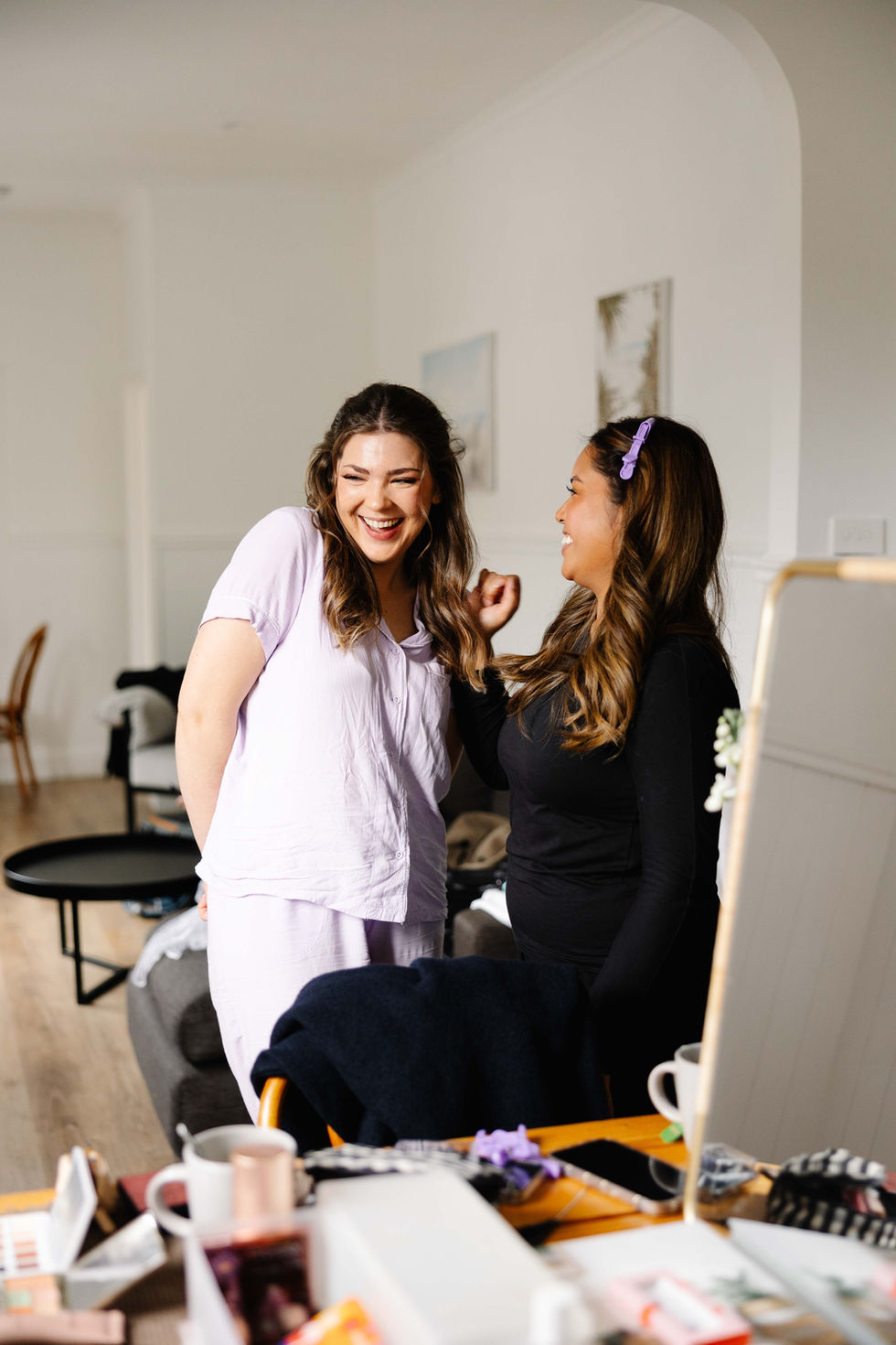 two women are laughing together in a living room