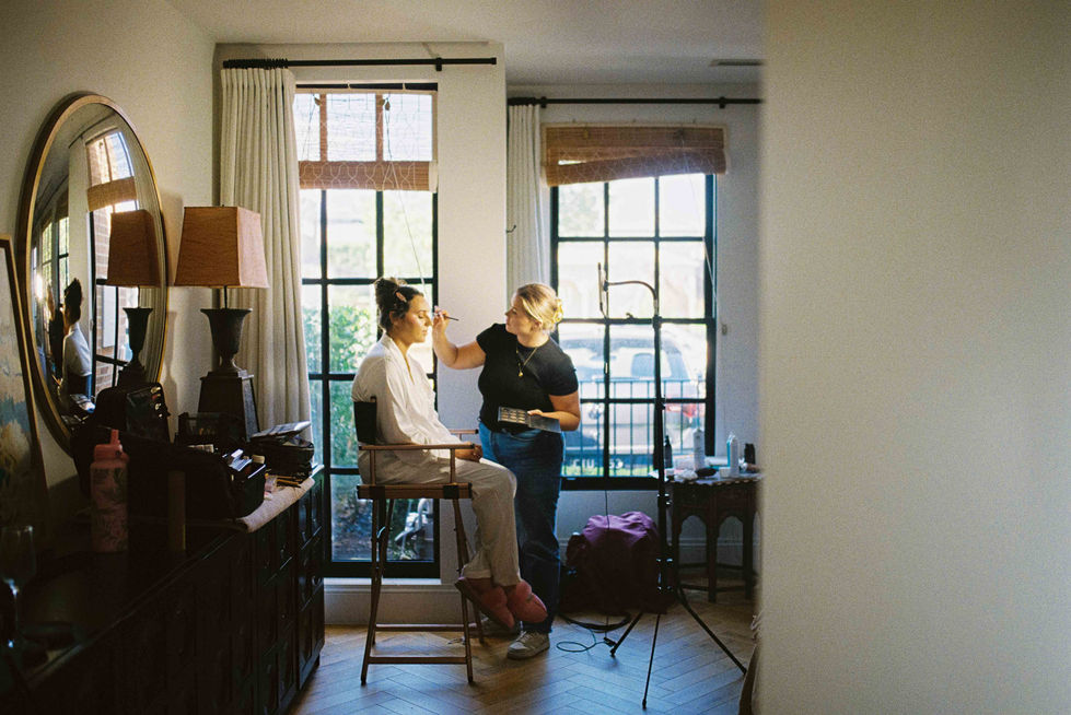 a woman is getting her makeup done in front of a window