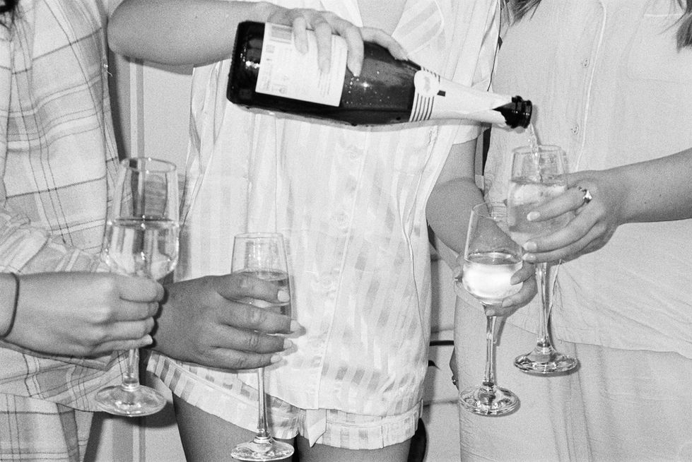 a woman pouring a bottle of champagne into a glass