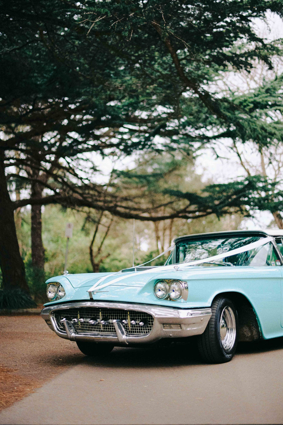 a blue car with a white ribbon on the hood