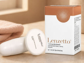 Lenzetto spray bottle and box on a beige surface, with soft towels in the background; product packaging in warm neutral tones