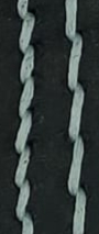 White thread on black leather, creating a sharp contrast.