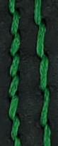 Green thread embedded in black leather.