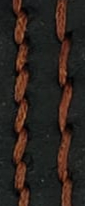 Auburn thread against black leather, creating depth.
