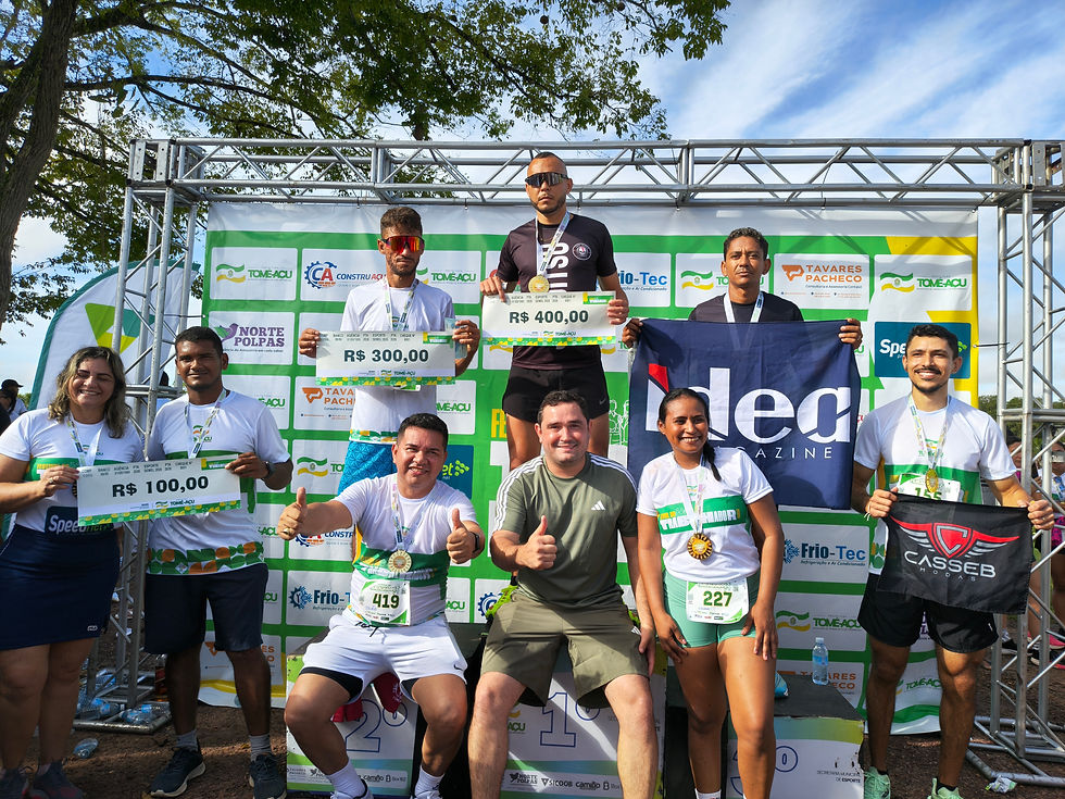 Pódio oficial da Corrida do Trabalhador 2026 em Tomé-Açu exibe os vencedores com seus cheques simbólicos e medalhas, cercados por patrocinadores e organizadores. A foto destaca a premiação e a valorização dos atletas locais na região amazônica.