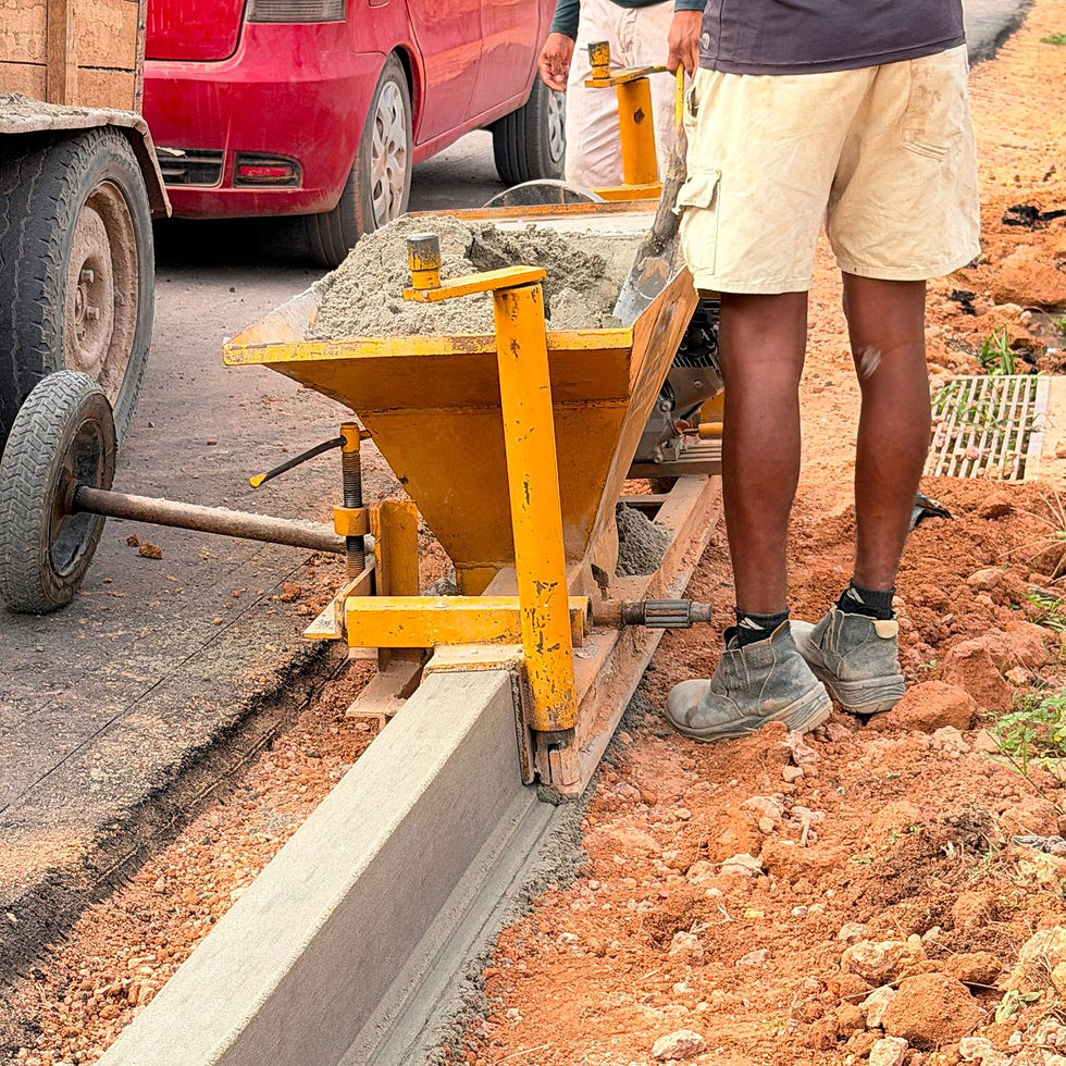 Operário posiciona máquina extrusora de meio-fio de concreto durante serviço de construção de guias na Rua do Coqueiro, Distrito de Forquilha, Tomé-Açu.