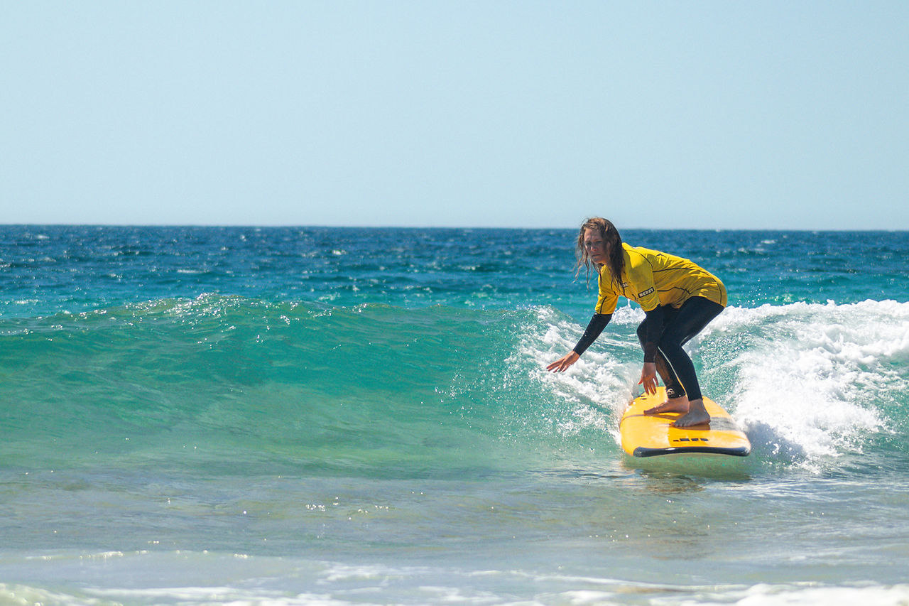 Wave surfing in Lanzarote, Famara, girl surfer, longboard