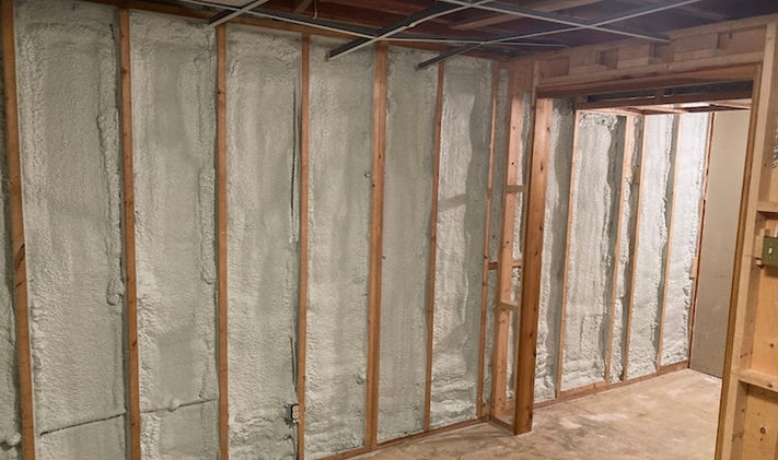 Basement wall insulated with spray foam