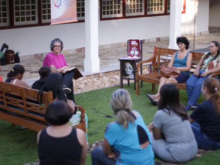 Mulheres conversam num jardim de um centro cultural