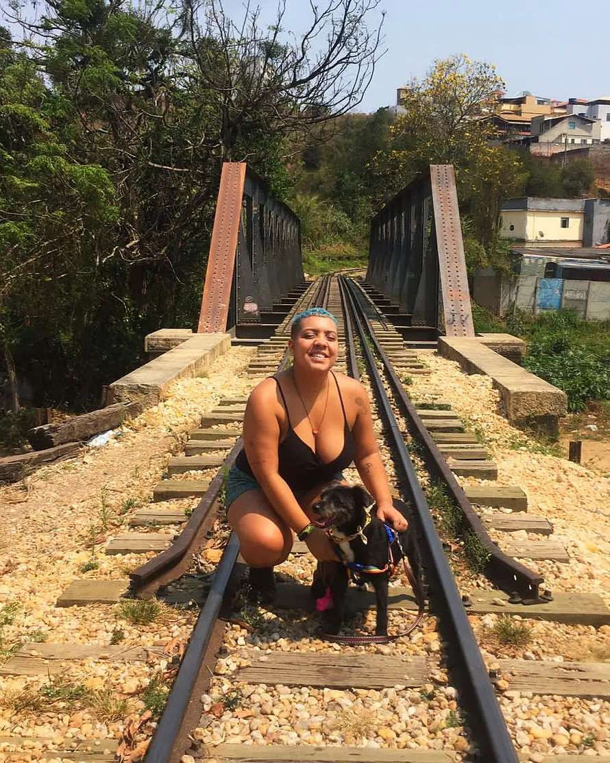 Jenny acaricia um cachorro nos trilhos de trem.