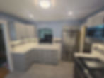 After kitchen remodel showing completed cabinets, range, refrigerator, and backsplash