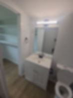 After photo of renovated dining room with chandelier and wood flooring