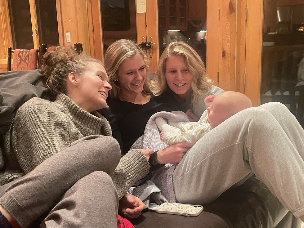 3 sisters holding a baby
