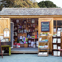 A Backyard Shed Shop with doors open and displays of kitchenwares and books