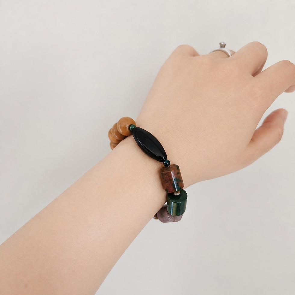 Thumbnail: Unisex gemstone bracelet worn on wrist featuring earthy tones, wood beads, and bold black stone centerpiece