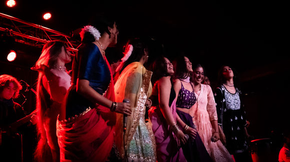 a group of women are dancing in a dark room