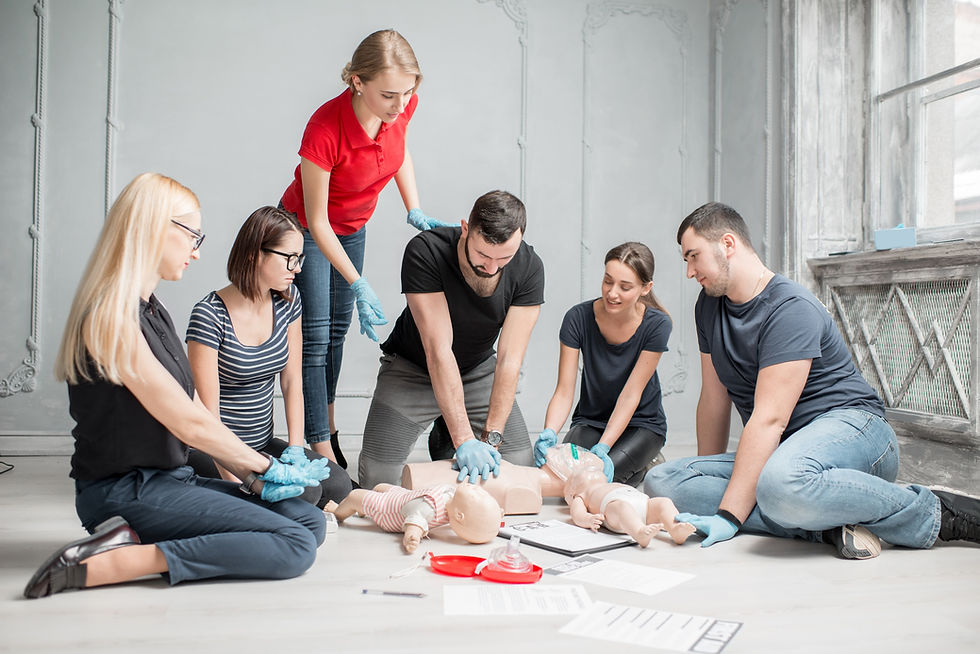 Group of adults learning how to perform CPR in a training setting