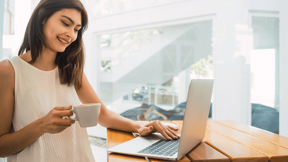 Woman with coffee typing on laptop