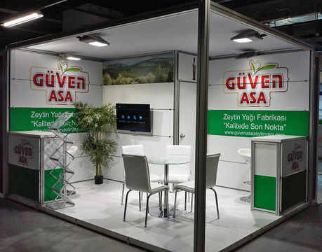Güven ASA standı, zeytin yağı fabrikası, beyaz masa ve sandalyeler sergileniyor.