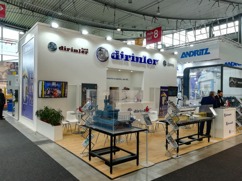 dirinler standı, beyaz zemin, mavi logolar, sergilenen ürünler, Yurt Dışı Fuar Standı