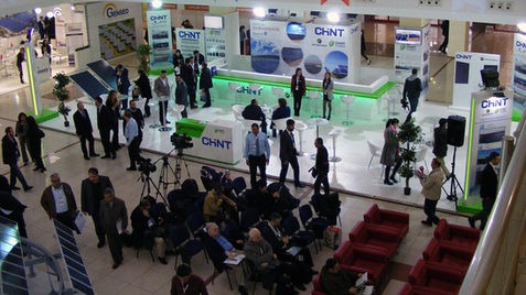 Chint's booth features a modern product display area where circuit breakers and smart switchgear are showcased on transparent plexiglass panels, supported by technical data screens.