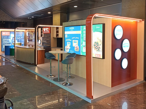 Fuar alanında modern bir stand, beyaz masa ve sandalyeler ile düzenlenmiş fuar standı.