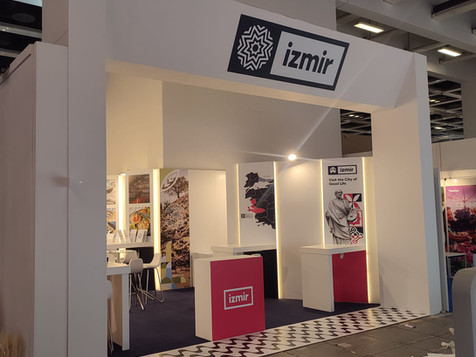 İzmir yazılı fuar standı, beyaz stand, pembe detaylar, yurt dışı fuar standı, ürün tanıtımı.