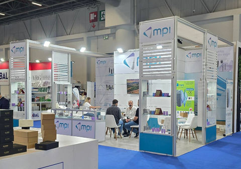 MPI standı, ziyaretçilerle dolu, mavi zemin üzerinde, beyaz ve mavi renkler.