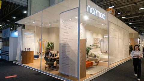 Normod fuar standı bünyesinde, markanın en yeni köşe koltuk ve berjer gruplarıyla dekore edilmiş, halı ve aksesuar detaylarıyla ev sıcaklığı sunan profesyonel networking alanı.