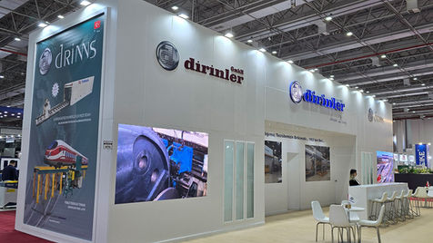 The Dirinler Makine stand features modern product display units with focused lighting, showcasing the digital control panels and advanced software solutions of the machines.