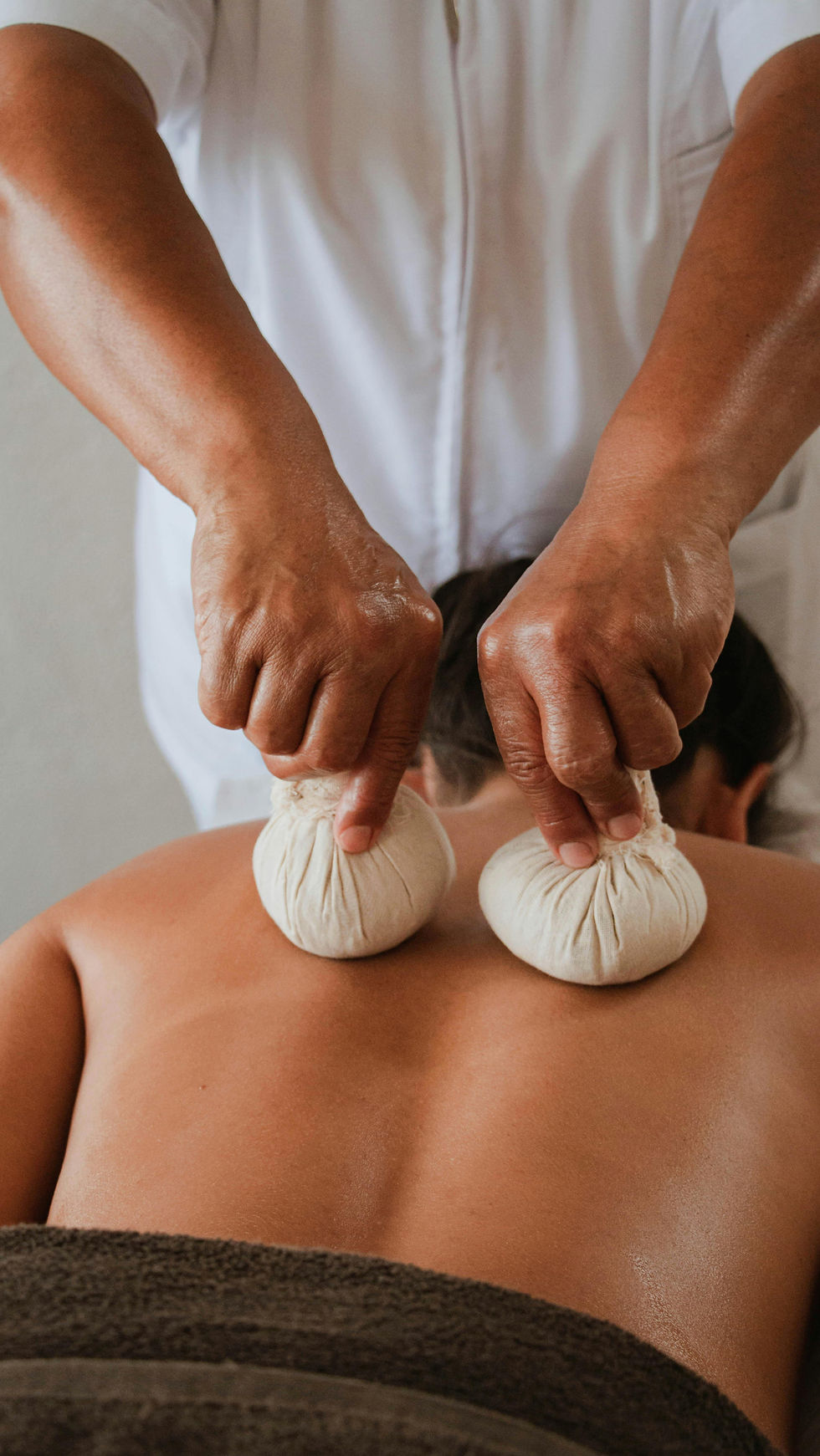 Herbal compress massage on a person's back