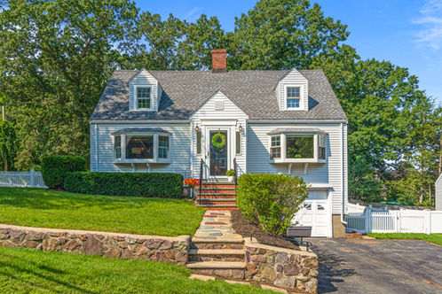cape style home with wreath on the door