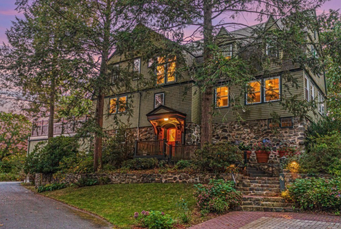 evening photo of green colonial home