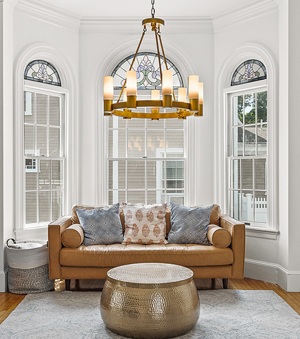 Living room with brown leather couch in window nook
