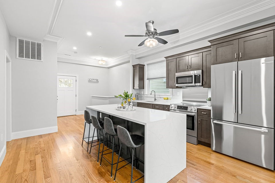new kitchen with brown cabinets and white island