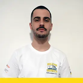 Professional portrait of George T wearing a white Balkan Dispatch branded shirt