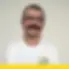 Professional portrait of Nick A smiling and wearing glasses with a white Balkan Dispatch branded shirt