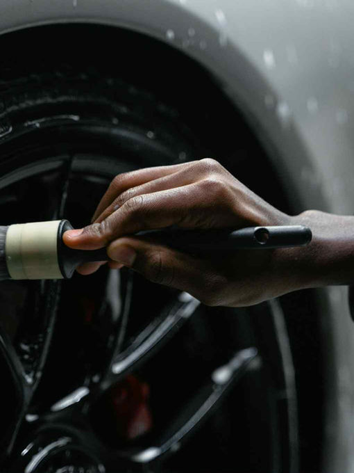 Technician cleaning car wheel during auto spa in Summit IL