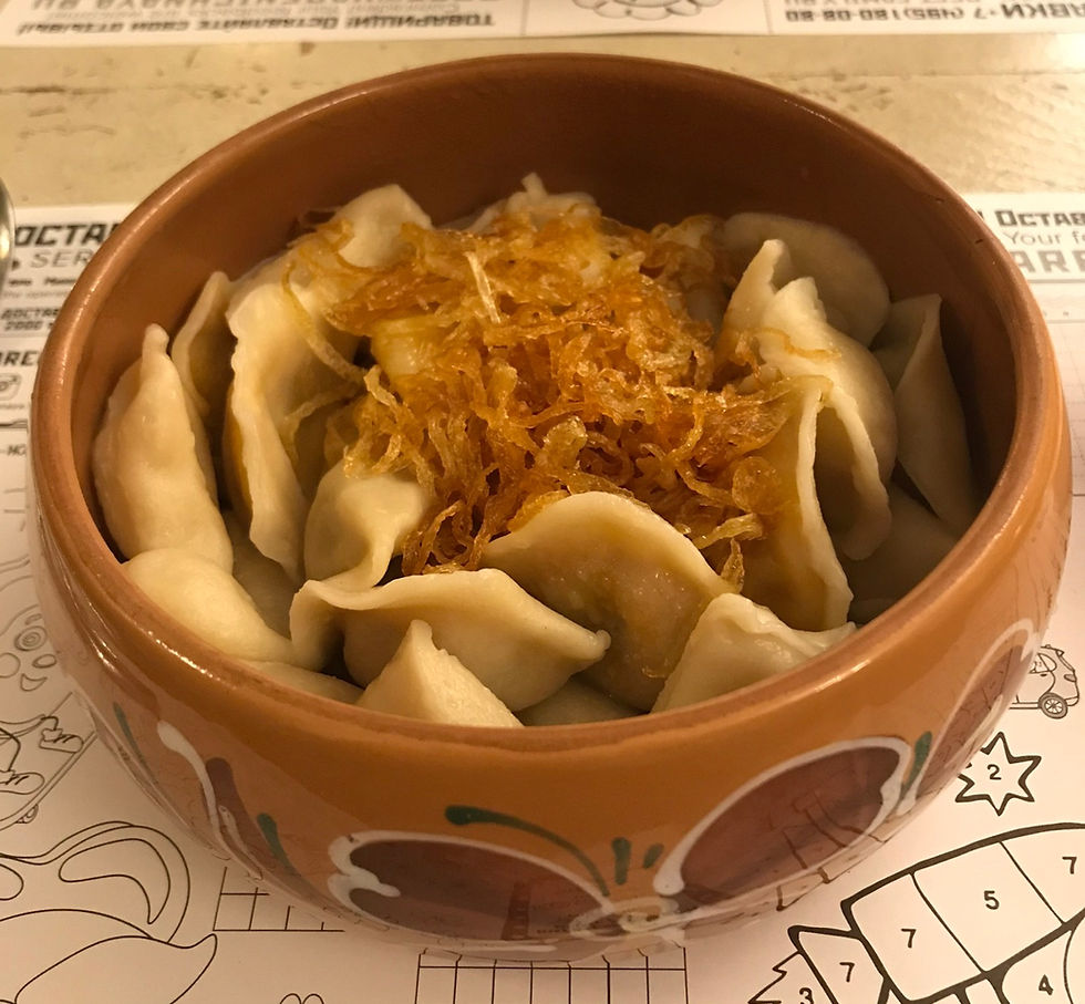 Bowl of various dumplings with onions on top, Moscow Russia