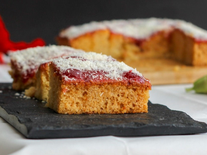 It is a very easy cake recipe prepared with no fancy equipment. This cake consists of a vanilla base drizzled with honey syrup and topped with jam and coconut. This flavoured cake is hugely popular in south India.