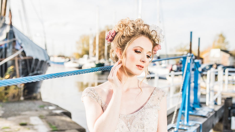 Bride with up do and flowers in her hair. Autumnal bridal make up. Bride poses for Essex wedding photographer Laura Jane Photography.