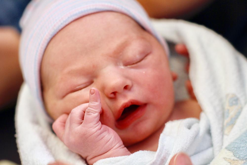 A Caucasian Newborn baby giving feeding cues