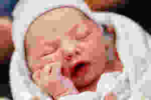 A Caucasian Newborn baby giving feeding cues