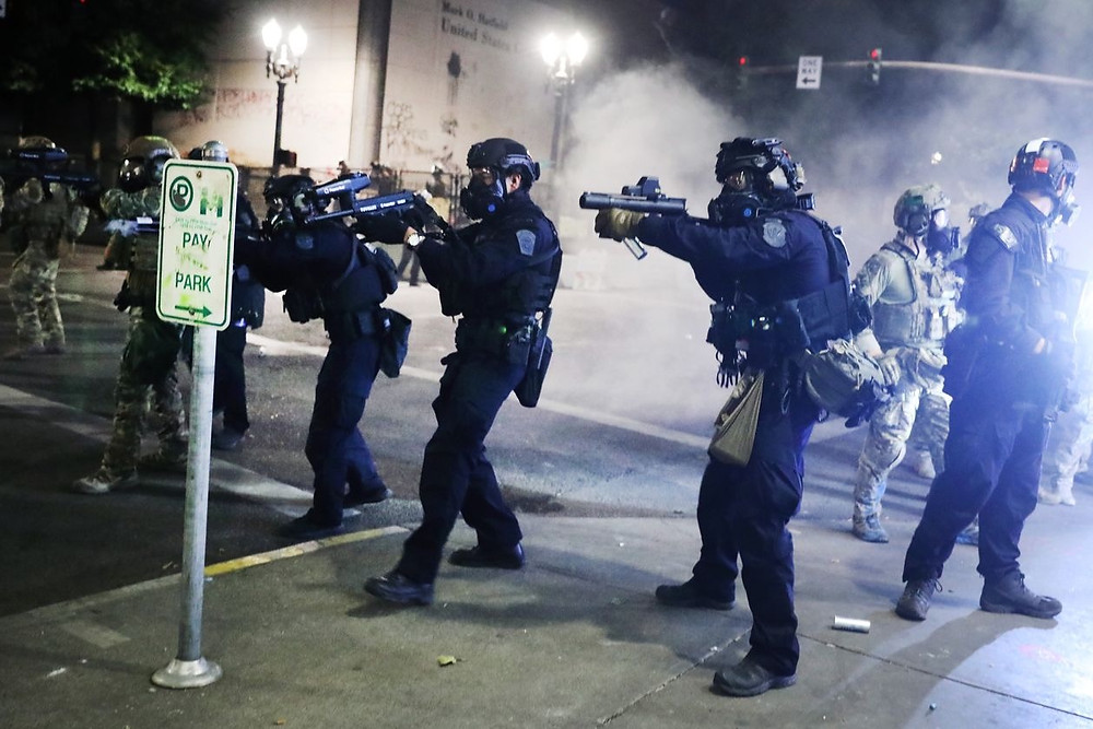 Police pointing guns at protestors.