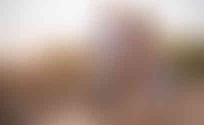 Dad holding mom's belly while son holds mom's hand