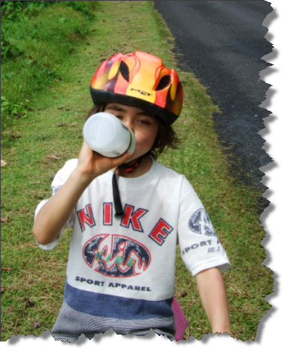 Boy drinking water while riding a bike in Samoa